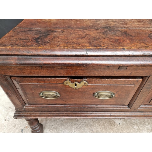 1098 - An 18th century oak two drawer side table, 131cm wide, (alterations).