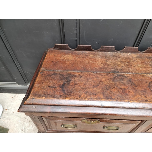 1098 - An 18th century oak two drawer side table, 131cm wide, (alterations).