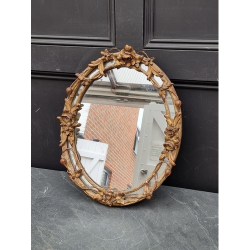 1122 - A 19th century gilt framed oval wall mirror, with trailing foliage, 51 x 42.5cm. ... 