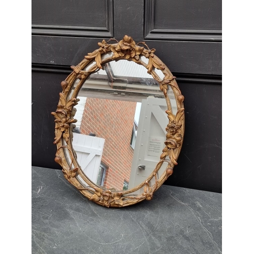 1122 - A 19th century gilt framed oval wall mirror, with trailing foliage, 51 x 42.5cm. ... 