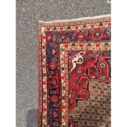 1131 - A Persian rug, having central floral medallion, with geometric floral cartouches to each corner, wit... 