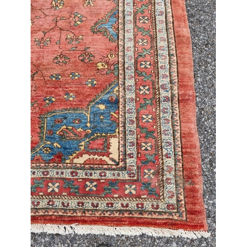 1132 - A Persian style rug, having central floral medallion, with floral cartouches to each corner, 255 x 1... 