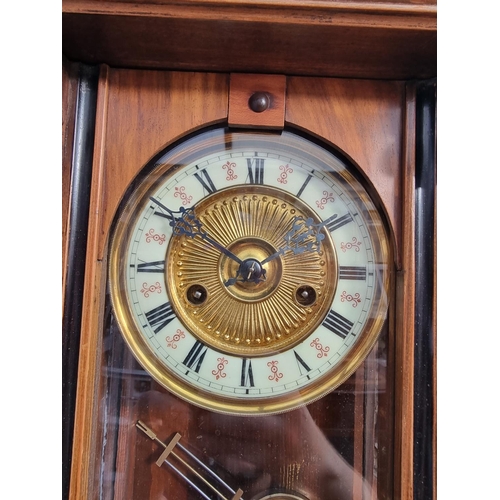 1150 - A circa 1900 walnut and stained wood wall clock, 60cm high, with pendulum.