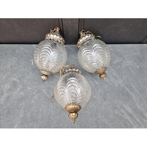 1247 - A set of three moulded glass and brass ceiling lanterns, approx 35cm high.