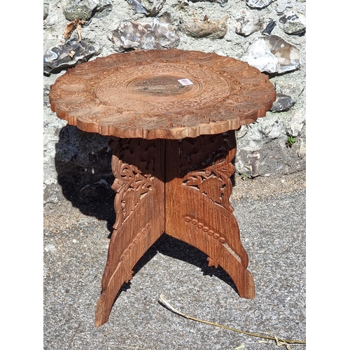 1108 - An Eastern carved hardwood and brass inlaid folding occasional table, 44.5cm diameter.... 