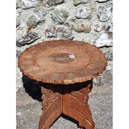 1108 - An Eastern carved hardwood and brass inlaid folding occasional table, 44.5cm diameter.... 