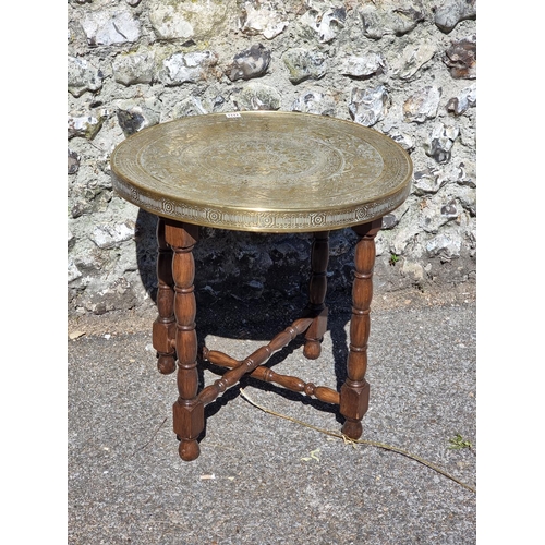 1111 - A brass top folding occasional table, 60cm diameter.