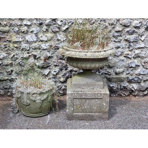 1669 - A weathered composition stone urn and pedestal, 73cm high x 58cm diameter; together with another sim... 