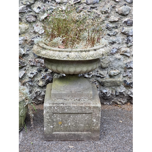 1669 - A weathered composition stone urn and pedestal, 73cm high x 58cm diameter; together with another sim... 