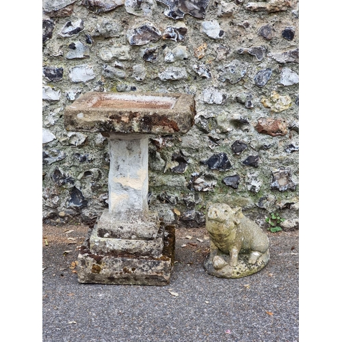 1670 - An old weathered composition stone birdbath, 68cm high x 45cm wide; together with a similar pig, 30c... 