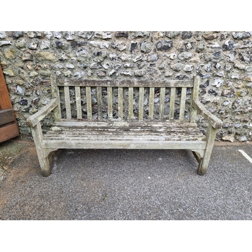 1673 - A weathered teak garden bench, by Lister, 152.5cm wide, (a.f.).