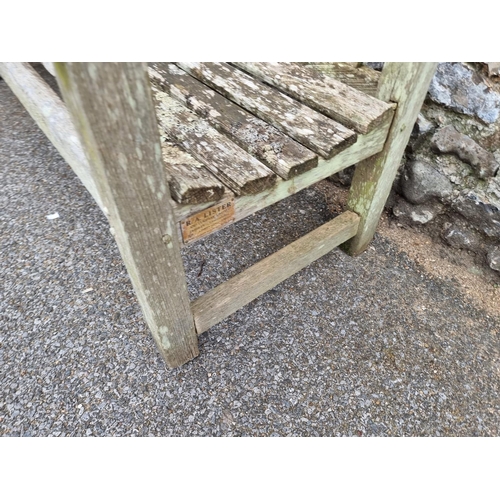 1673 - A weathered teak garden bench, by Lister, 152.5cm wide, (a.f.).