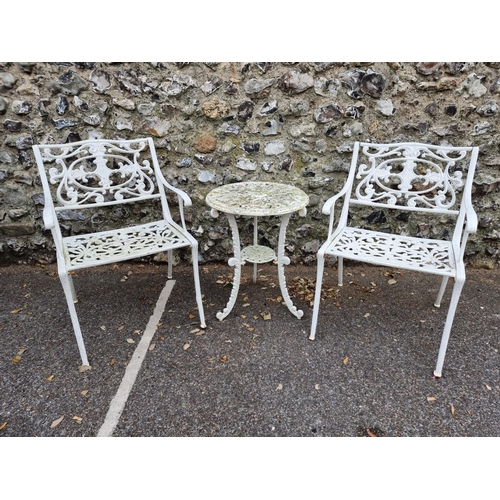 1675 - A pair of white painted cast iron garden chairs; and a similar circular table, 45cm diameter. (3)... 