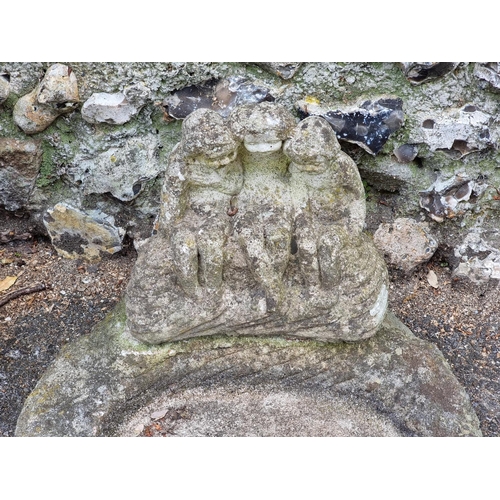 1677 - A composition stone garden figure, emblematic of winter, 76cm high; and a similar birdbath, 46cm wid... 