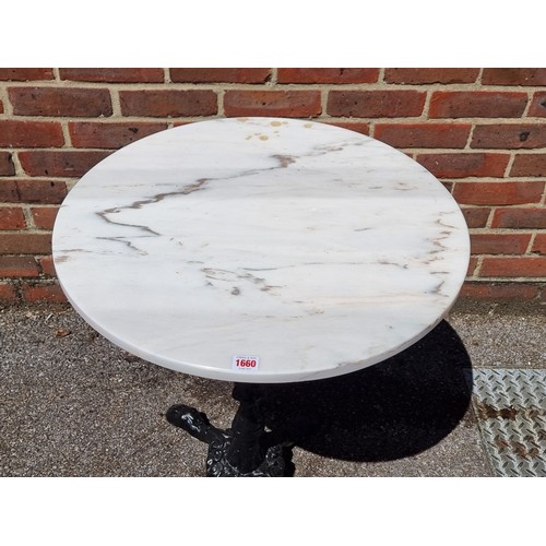 1660 - A cast iron and marble top cafe table, 70cm high x 60.5cm diameter.