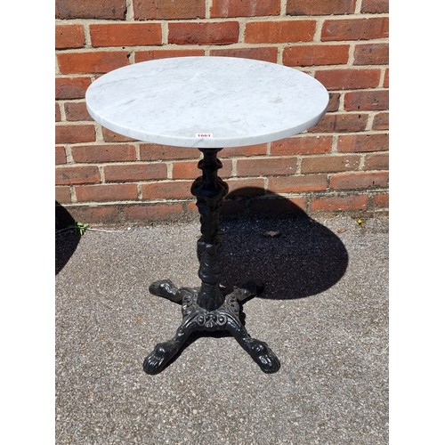 1661 - A cast iron and marble top cafe table, 70cm high x 52cm diameter.