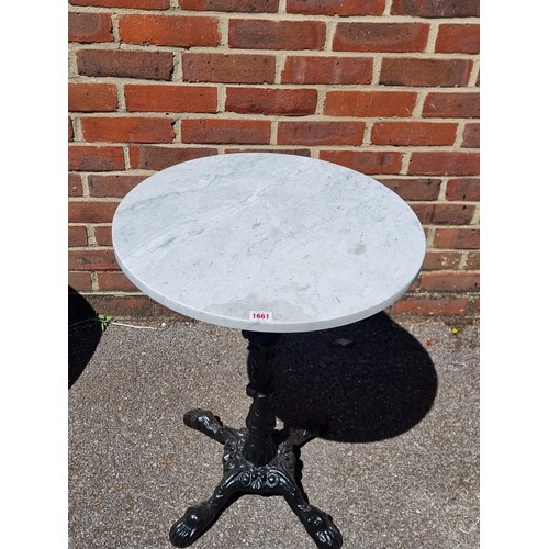 1661 - A cast iron and marble top cafe table, 70cm high x 52cm diameter.