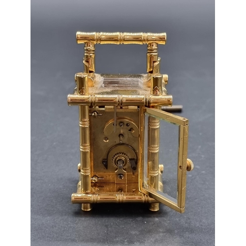 1147 - A small brass simulated bamboo carriage timepiece, height including handle 9.5cm, with winding key.... 