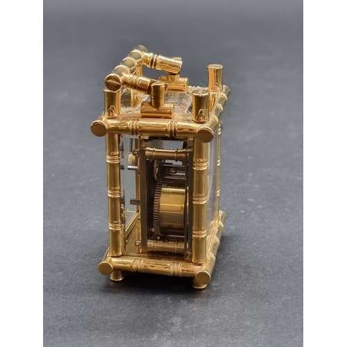 1147 - A small brass simulated bamboo carriage timepiece, height including handle 9.5cm, with winding key.... 