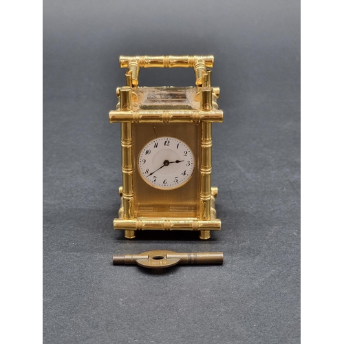 1147 - A small brass simulated bamboo carriage timepiece, height including handle 9.5cm, with winding key.... 