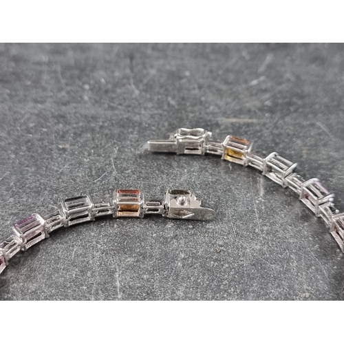 240 - A white metal multicoloured sapphire and diamond set bracelet, stamped 750, having twenty octagonal ... 