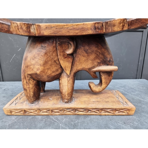 1008 - Ethnographica: a carved hardwood elephant stool, 50cm wide.