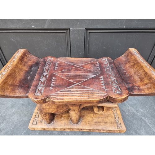 1008 - Ethnographica: a carved hardwood elephant stool, 50cm wide.