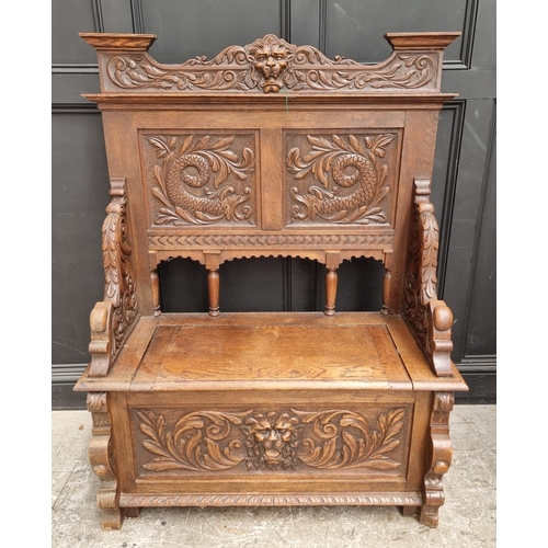 1015 - A late Victorian carved oak box seat settle, 109.5cm wide.