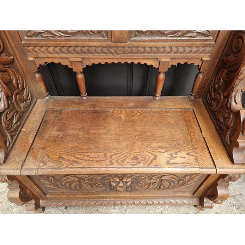 1015 - A late Victorian carved oak box seat settle, 109.5cm wide.