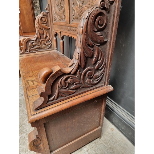 1015 - A late Victorian carved oak box seat settle, 109.5cm wide.