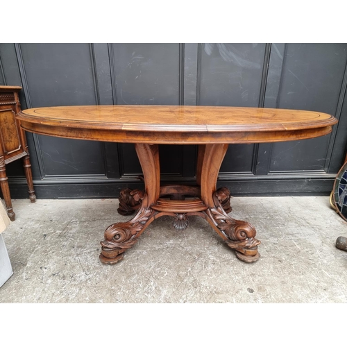 1020 - A good Victorian figured walnut oval loo table, with dolphin base, 152cm wide.