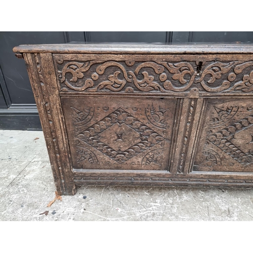 1027 - A late 17th century carved oak panelled coffer, 106.5cm wide.