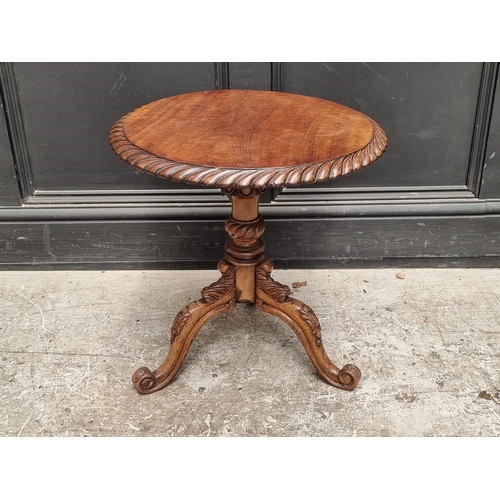 1030 - A small 19th century carved walnut low tripod table, 47cm wide. 