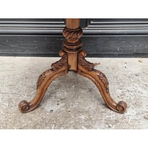 1030 - A small 19th century carved walnut low tripod table, 47cm wide. 