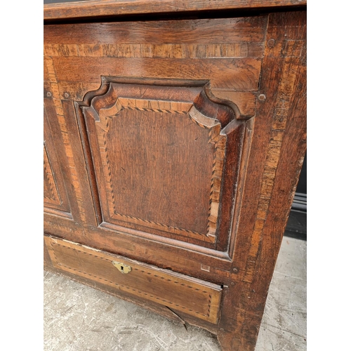 1035 - An 18th century oak and inlaid panelled mule chest, 147.5cm wide.