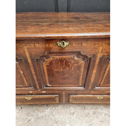 1035 - An 18th century oak and inlaid panelled mule chest, 147.5cm wide.