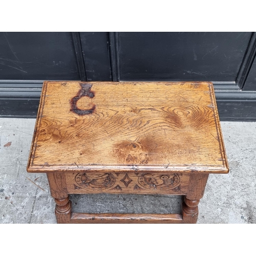 1037 - A 17th century style carved oak box seat joint stool, the frieze decorated with two Romayne hea... 