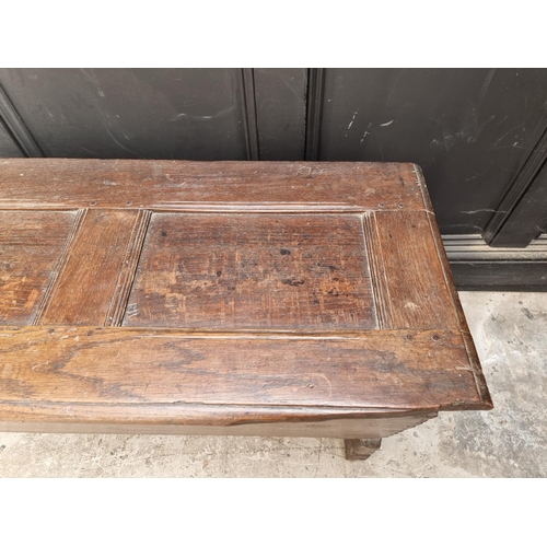 1039 - An unusual 17th century elm and oak boarded coffer, of tapered profile, 152.5cm wide.... 