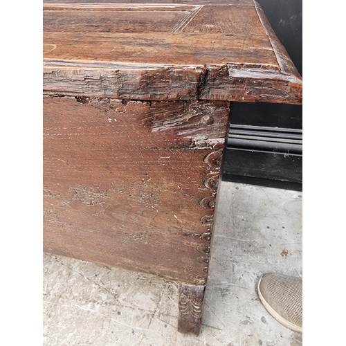 1039 - An unusual 17th century elm and oak boarded coffer, of tapered profile, 152.5cm wide.... 