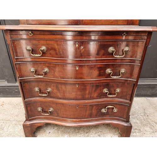 1050 - An 18th century style mahogany and inlaid bookcase, the serpentine chest base with brushing sli... 