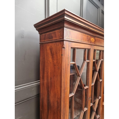 1050 - An 18th century style mahogany and inlaid bookcase, the serpentine chest base with brushing sli... 