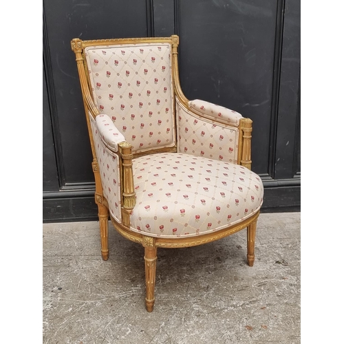 1065 - A Louis XVI style carved giltwood fauteuil.