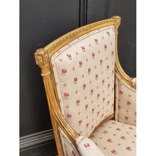 1065 - A Louis XVI style carved giltwood fauteuil.