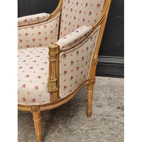 1065 - A Louis XVI style carved giltwood fauteuil.