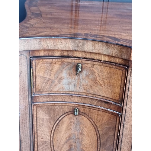 1069 - A George III mahogany, line inlaid and crossbanded serpentine fronted sideboard, 153cm wide.... 