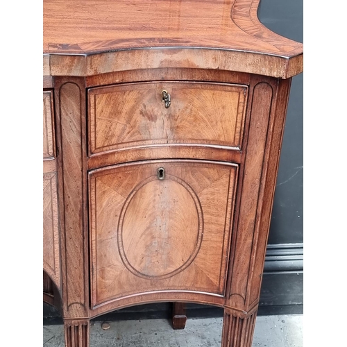 1069 - A George III mahogany, line inlaid and crossbanded serpentine fronted sideboard, 153cm wide.... 