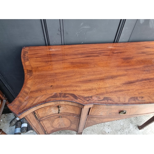 1069 - A George III mahogany, line inlaid and crossbanded serpentine fronted sideboard, 153cm wide.... 