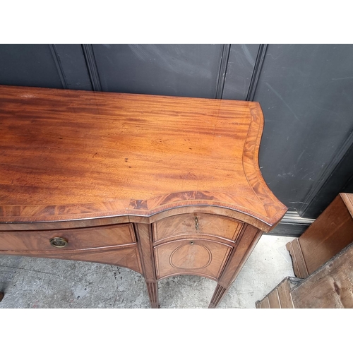 1069 - A George III mahogany, line inlaid and crossbanded serpentine fronted sideboard, 153cm wide.... 