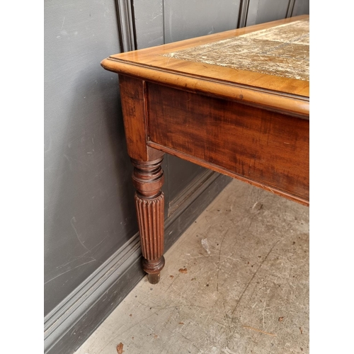 1075 - An early 19th century mahogany partners' desk, on reeded legs, 119 x 152cm.