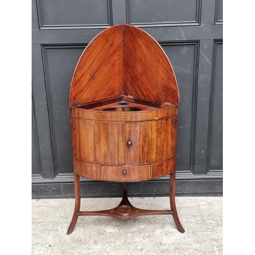 1093 - A George III mahogany corner wash stand, with hinged splashback, 67.5cm wide.